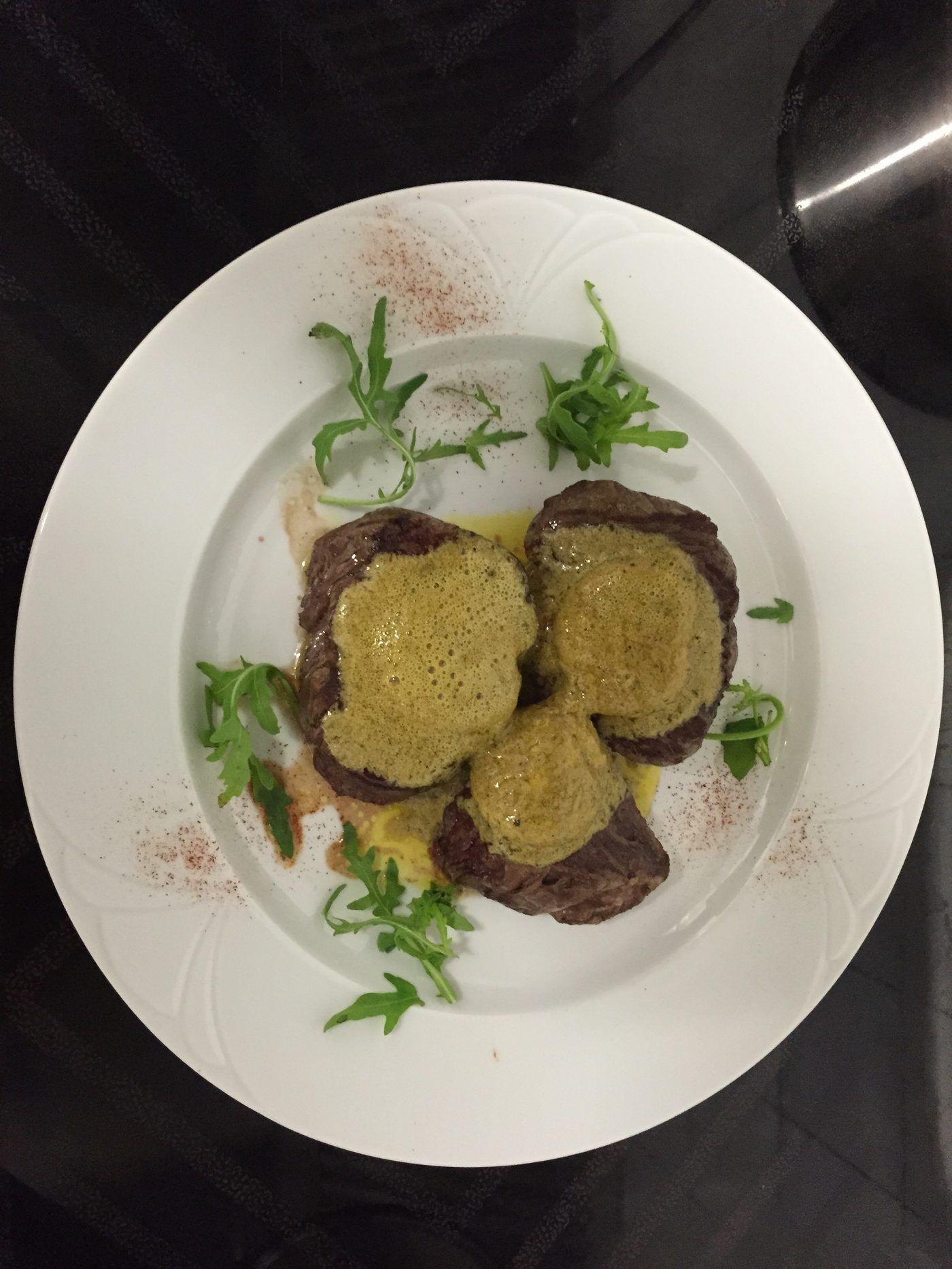 Angus-Rindsfilet mit Kräuterschaum überbacken, angerichtet auf dem Teller