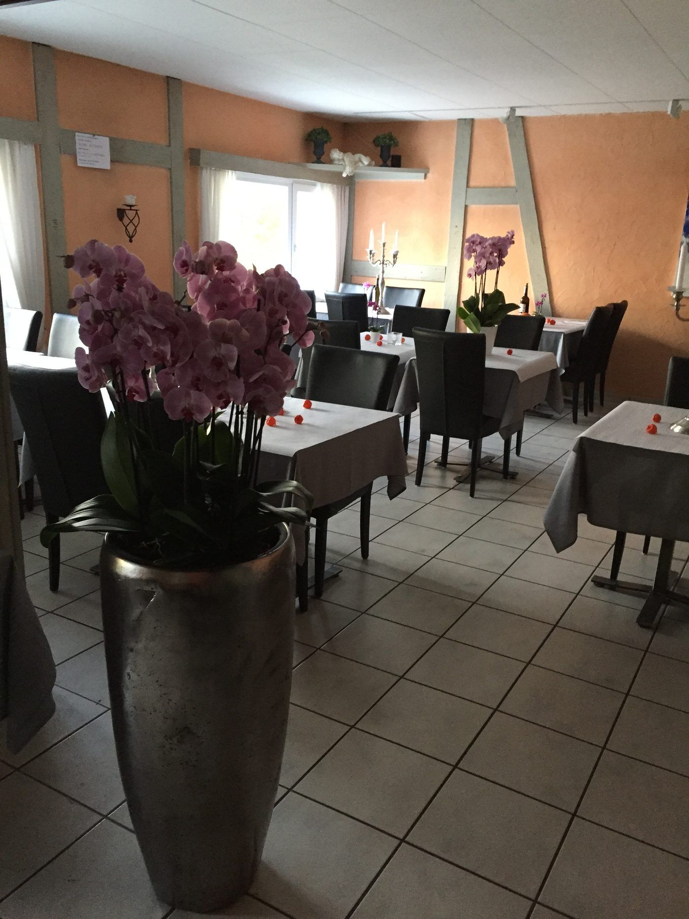 Blick in den Gastraum des Rustica mit gedeckten Tischen und Orchideen